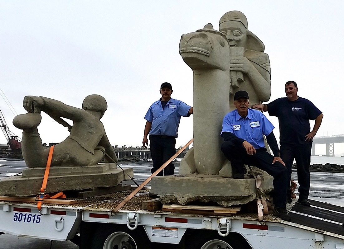 men loading a statue on to a truck